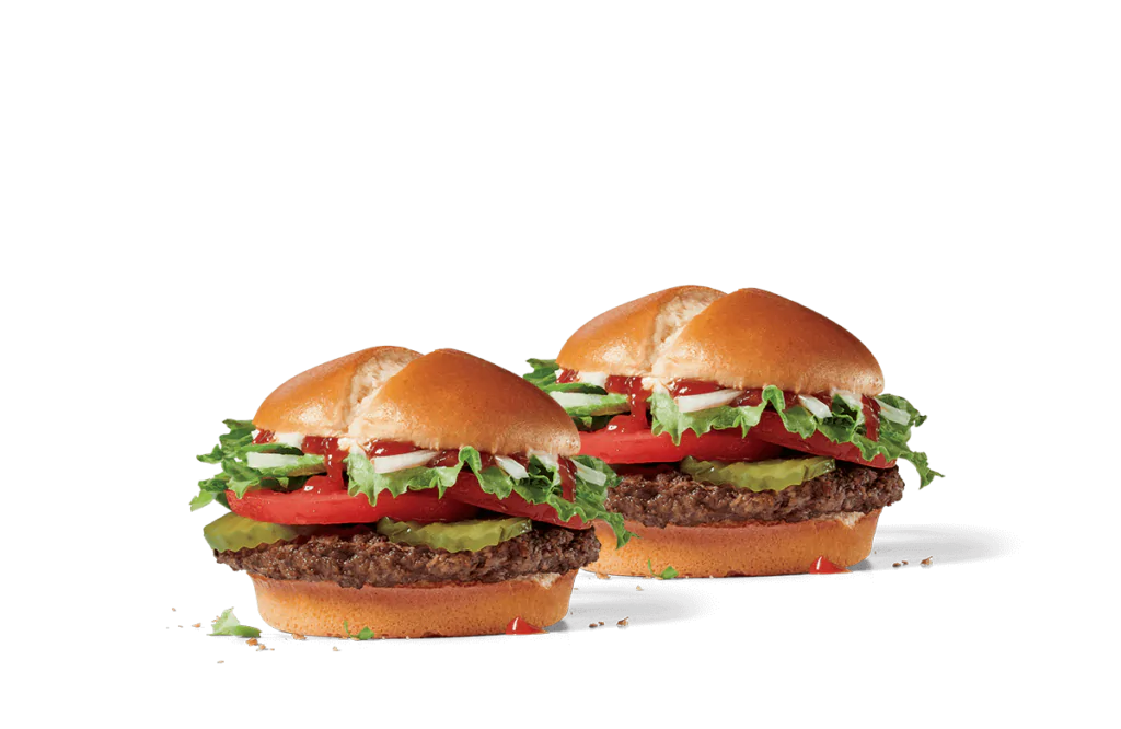 Two veggie burgers with glossy buns, loaded with a thick beef patty, crisp lettuce, fresh tomato slices, creamy mayonnaise, and bright green avocado on a transparent background.