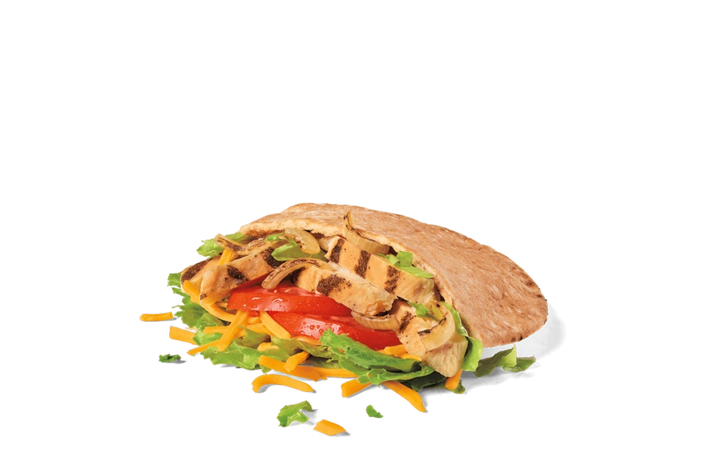 A freshly prepared chicken fajita pita sandwich overflowing with grilled chicken strips, sliced ripe tomatoes, shredded lettuce, and grated cheese, all encased in a warm, lightly toasted pita bread, presented on transparent background with scattered ingredients.