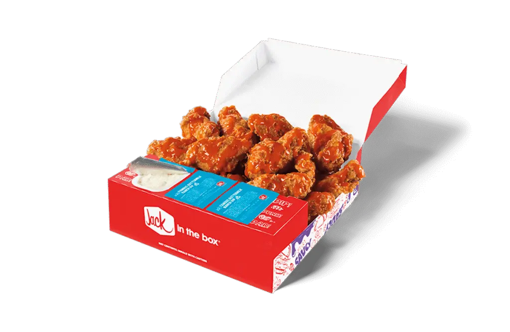 A 12-piece Buffalo Crispy Chicken Wings box from Jack in the Box, showcasing golden-brown crispy wings coated in a vibrant buffalo sauce. The box includes dipping sauce and moist towelette packets, all arranged in a red box featuring the Jack in the Box logo. The open lid displays the wings in a tempting, ready-to-eat presentation.