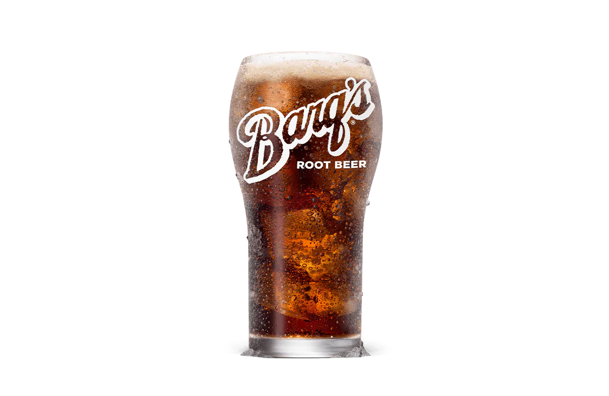 A chilled glass of Barq's® Root Beer filled with ice, showcasing a dark and fizzy beverage topped with foam, perfect for refreshing enjoyment.