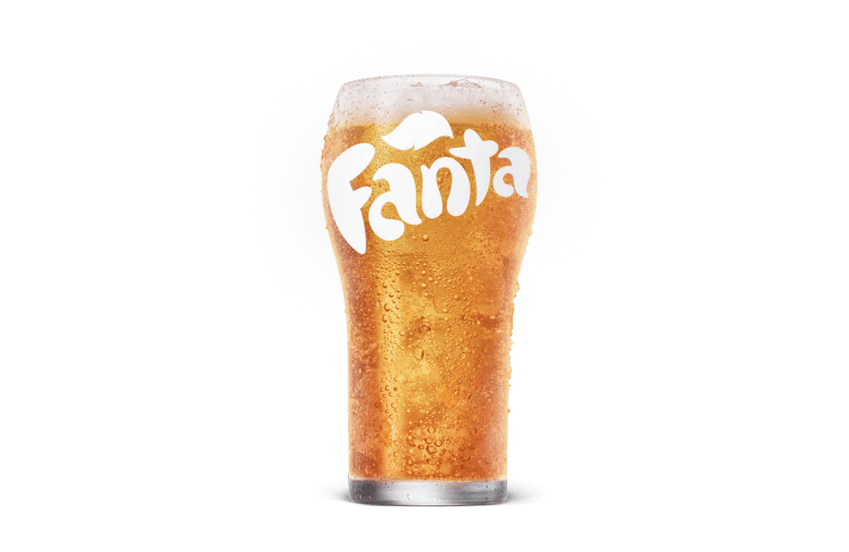A cold glass of Fanta, showing vibrant orange soda with bubbles and the Fanta logo frosted onto the surface of the glass, set against transparent background.
