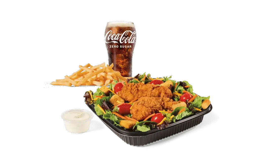 A garden salad topped with crispy chicken strips, served with fries, a cup of ranch dressing, and a Coca-Cola Zero Sugar drink.