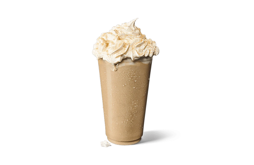 A tall glass of Iced Churro Creamaccino, featuring a creamy coffee base with a frosty texture. The drink is topped with a generous swirl of whipped cream dusted with cinnamon, capturing the essence of churro flavors. Small droplets of condensation on the glass highlight its chilled nature, set against transparent background for an appetizing presentation.