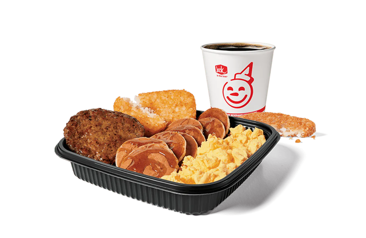 A hearty Jumbo Breakfast Platter from Jack in the Box, featuring scrambled eggs, savory sausage, crispy hash browns, and mini pancakes drenched in syrup, served alongside a hot cup of coffee, set against a transparent background for a satisfying meal.