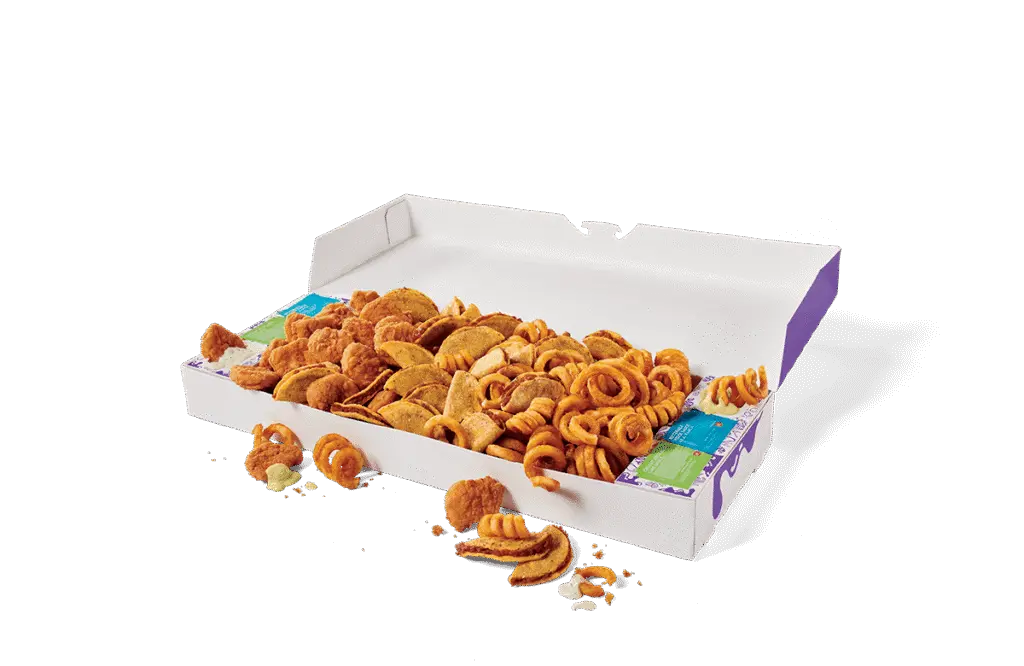 An open Mega Munchies Box from Jack in the Box, filled with a variety of snacks, including golden brown tacos, crispy chicken nuggets, and curly fries. The snacks are packed in a large rectangular box with purple accents, accompanied by dipping sauces in their individual containers. A few items are scattered outside the box on a clean surface, showcasing the assortment of treats.