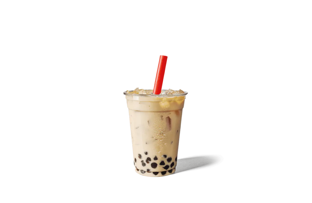 A tall clear plastic cup filled with creamy milk tea, ice cubes, and black tapioca pearls at the bottom, served with a vibrant red straw inserted through the lid. The drink appears refreshing and ready to enjoy.