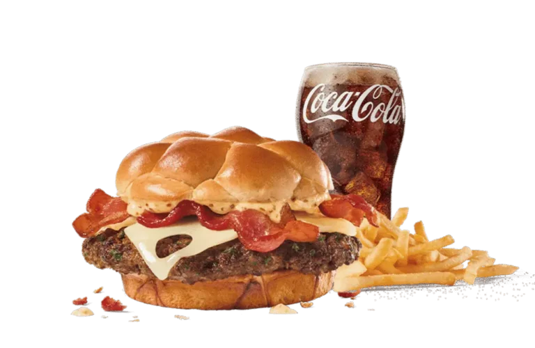 A Bacon Swiss Buttery Smashed Jack™ burger loaded with bacon, Swiss cheese, and a special sauce on a buttery bun, served with crispy fries and a cold Coca-Cola, set against transparent background.