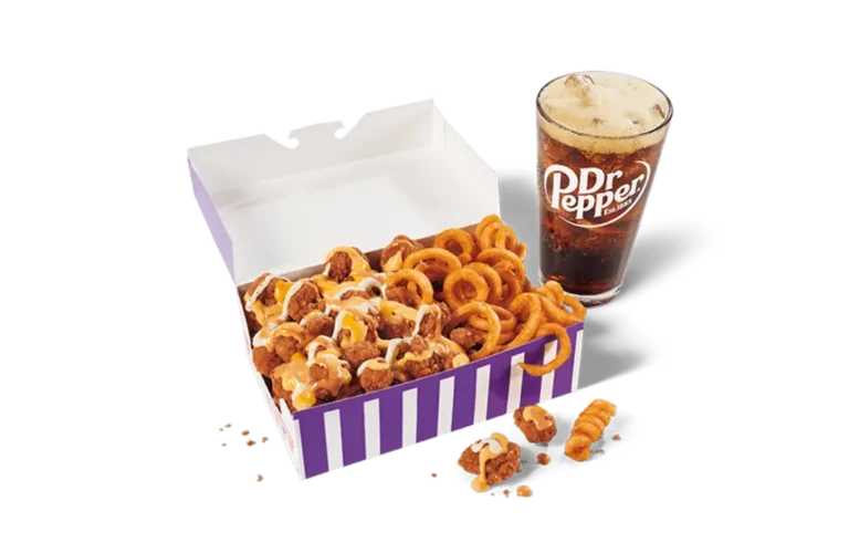 A serving of spicy sauced loaded popcorn chicken in a white and purple striped box, topped with cheese sauce and curly fries, accompanied by a glass of Dr Pepper with a foamy head, against transparent background.