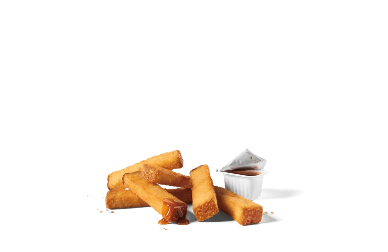 A serving of six golden, crispy French toast sticks accompanied by a container of dipping syrup, presented on transparent background.