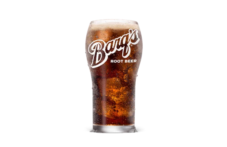A chilled glass of Barq's® Root Beer filled with ice, showcasing a dark and fizzy beverage topped with foam, perfect for refreshing enjoyment.