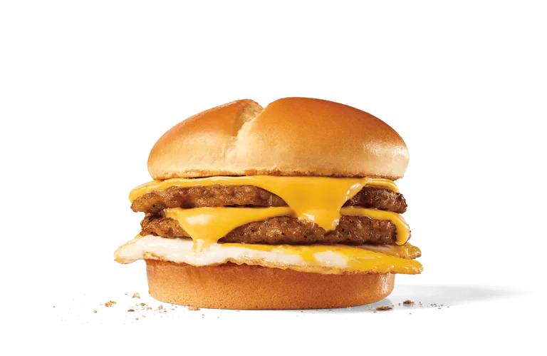 Image of an Extreme Sausage® Sandwich showcasing two savory sausage patties topped with melted American cheese and a fried egg, sandwiched between a soft, toasted hamburger bun.