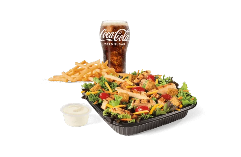 A fresh Garden Salad topped with grilled chicken strips, served with a side of French fries, a creamy dipping sauce, and a chilled Coca-Cola Zero Sugar drink.