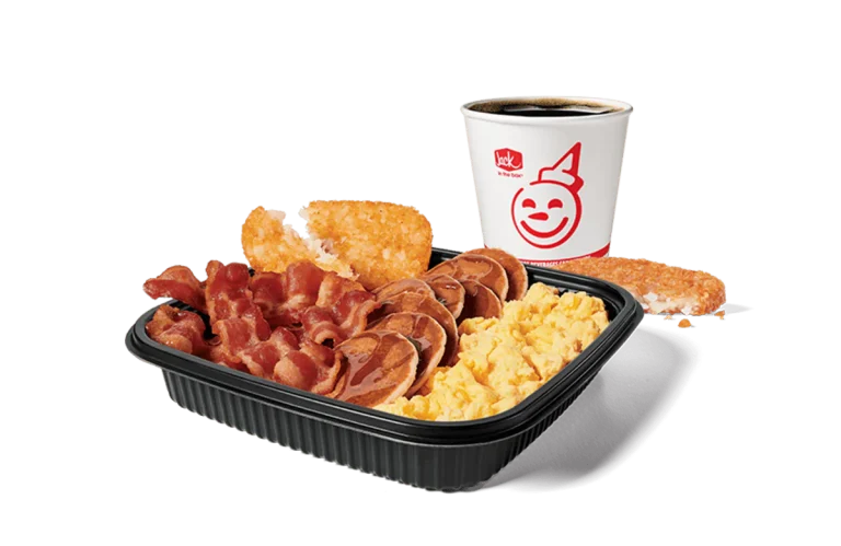 A mouth-watering Jumbo Breakfast Platter from Jack in the Box, featuring scrambled eggs, crispy bacon, hash browns, and mini pancakes, paired with a hot coffee. The meal is set against a transparent background, ideal for a filling and delicious breakfast.