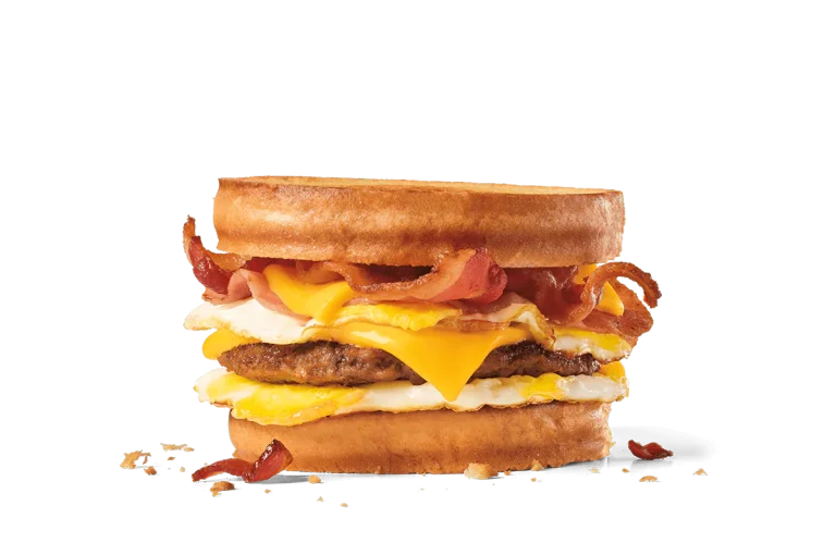 Image of a loaded breakfast sandwich with a juicy sausage patty, crispy bacon, a fried egg, and two slices of melted cheese, all stacked between two perfectly toasted slices of sourdough bread.