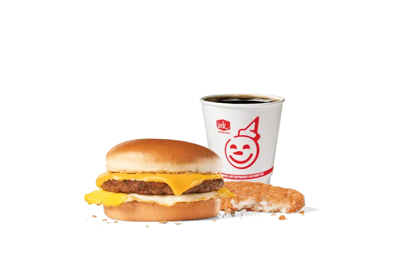 A delicious Sausage Breakfast Jack® Combo from Jack in the Box featuring a sandwich with a sausage patty, egg, and American cheese on a toasted bun. Paired with a crispy hash brown and a cup of hot coffee, set against a transparent background.