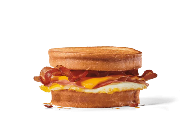 Image of a supreme sourdough breakfast sandwich featuring crispy bacon, a sunny-side-up egg, and melted cheese, layered between two golden-brown slices of toasted sourdough bread.