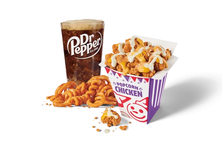 A delicious combo featuring sauced popcorn chicken with a drizzle of creamy sauce, crispy curly fries, and a refreshing Dr. Pepper drink.